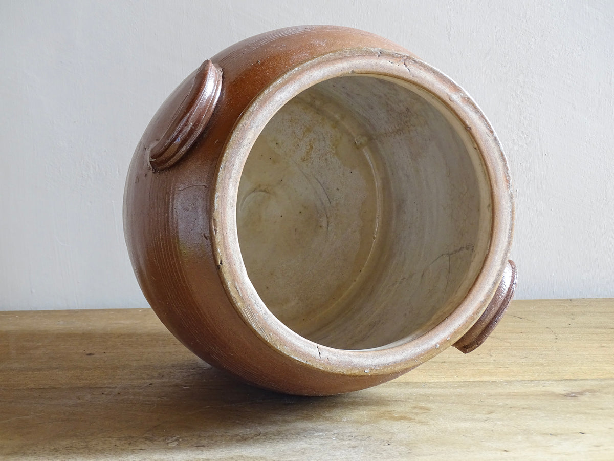 A French antique stoneware confit pot with a brown glaze. This is a salt glazed pottery cache pot. It dates to the early 20th century and would look amazing as part of a rustic French farmhouse style home.