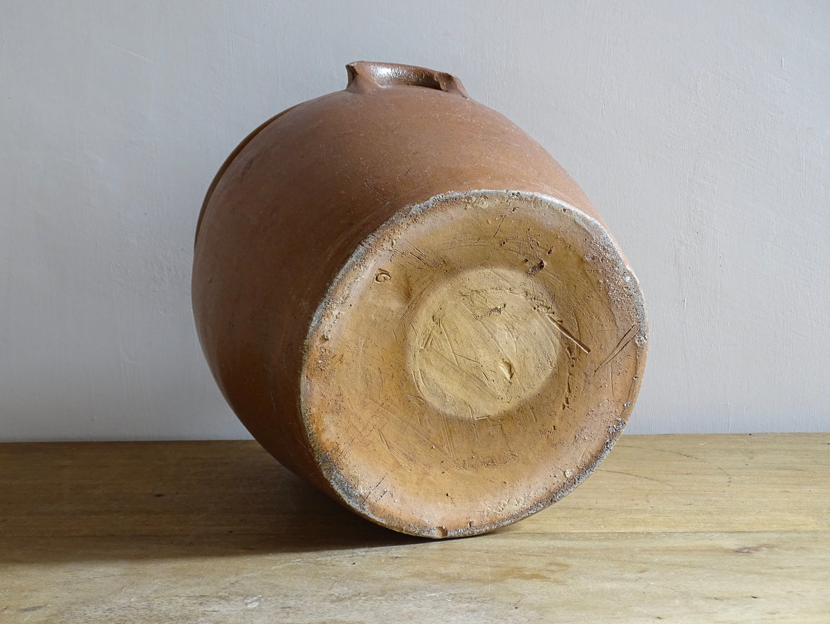 A French antique stoneware confit pot with a brown glaze. This is a salt glazed pottery cache pot. It dates to the early 20th century and would look amazing as part of a rustic French farmhouse style home.