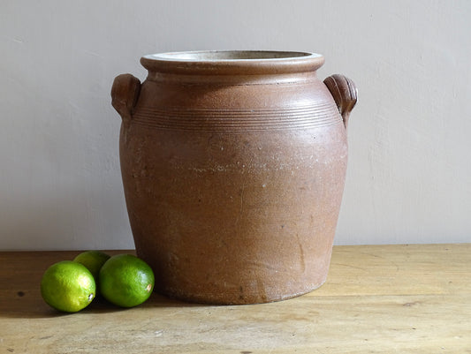 A French antique stoneware confit pot with a brown glaze. This is a salt glazed pottery cache pot. It dates to the early 20th century and would look amazing as part of a rustic French farmhouse style home.