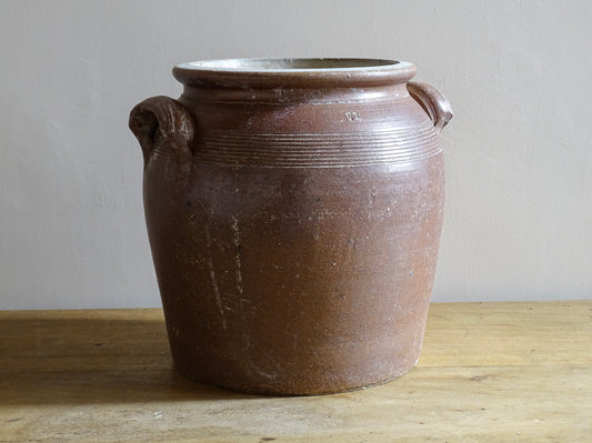A French antique stoneware confit pot with a brown glaze. This is a salt glazed pottery cache pot. It dates to the early 20th century and would look amazing as part of a rustic French farmhouse style home.