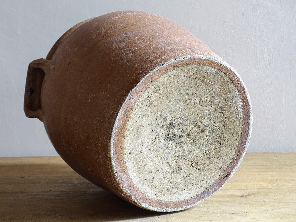 A French antique stoneware confit pot with a brown glaze. This is a salt glazed pottery cache pot. It dates to the early 20th century and would look amazing as part of a rustic French farmhouse style home.