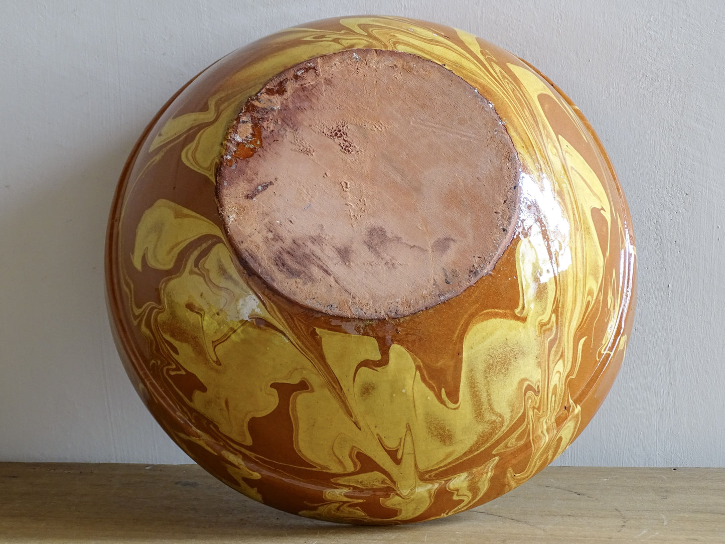 Base view of an antique French country pottery bowl with jaspe glaze and terracotta body