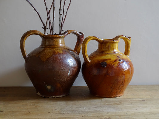 French antique pottery pitcher or orjol with golden caramel and yellow glaze. Antique terracotta cruche or jug with timeworn appearance.