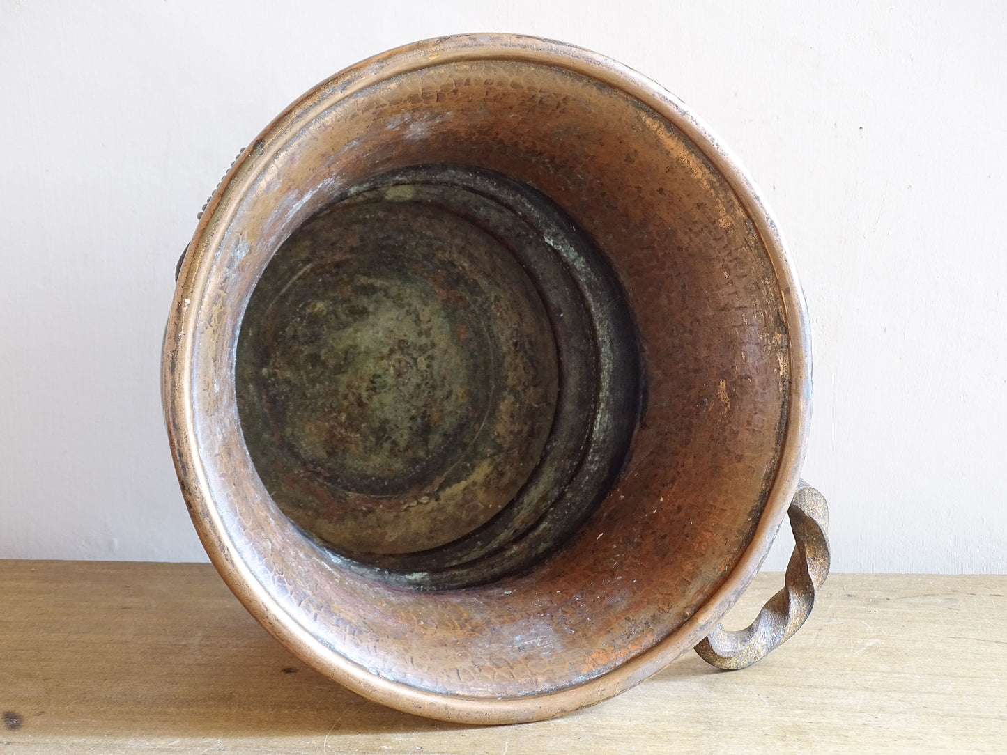 French antique hammered copper planter with iron handles. The copper has developed a rich, lived-in patina, with darker areas around the handles and base.