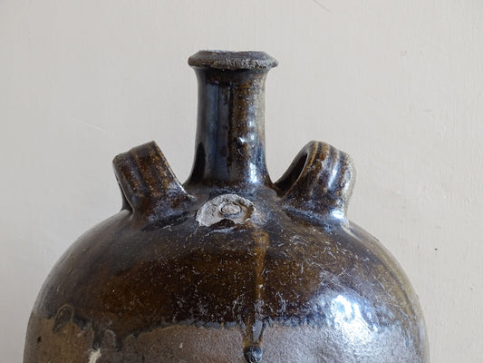 South West French pottery water vessel with central neck and worn surface