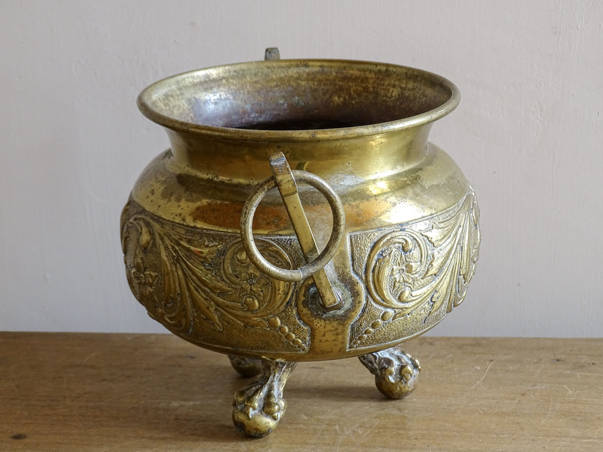 Highly ornate French antique brass jardinière with ball and claw feet. Dating to the late nineteenth century. It is such a decorative piece with richly detailed floral and scrolling relief.