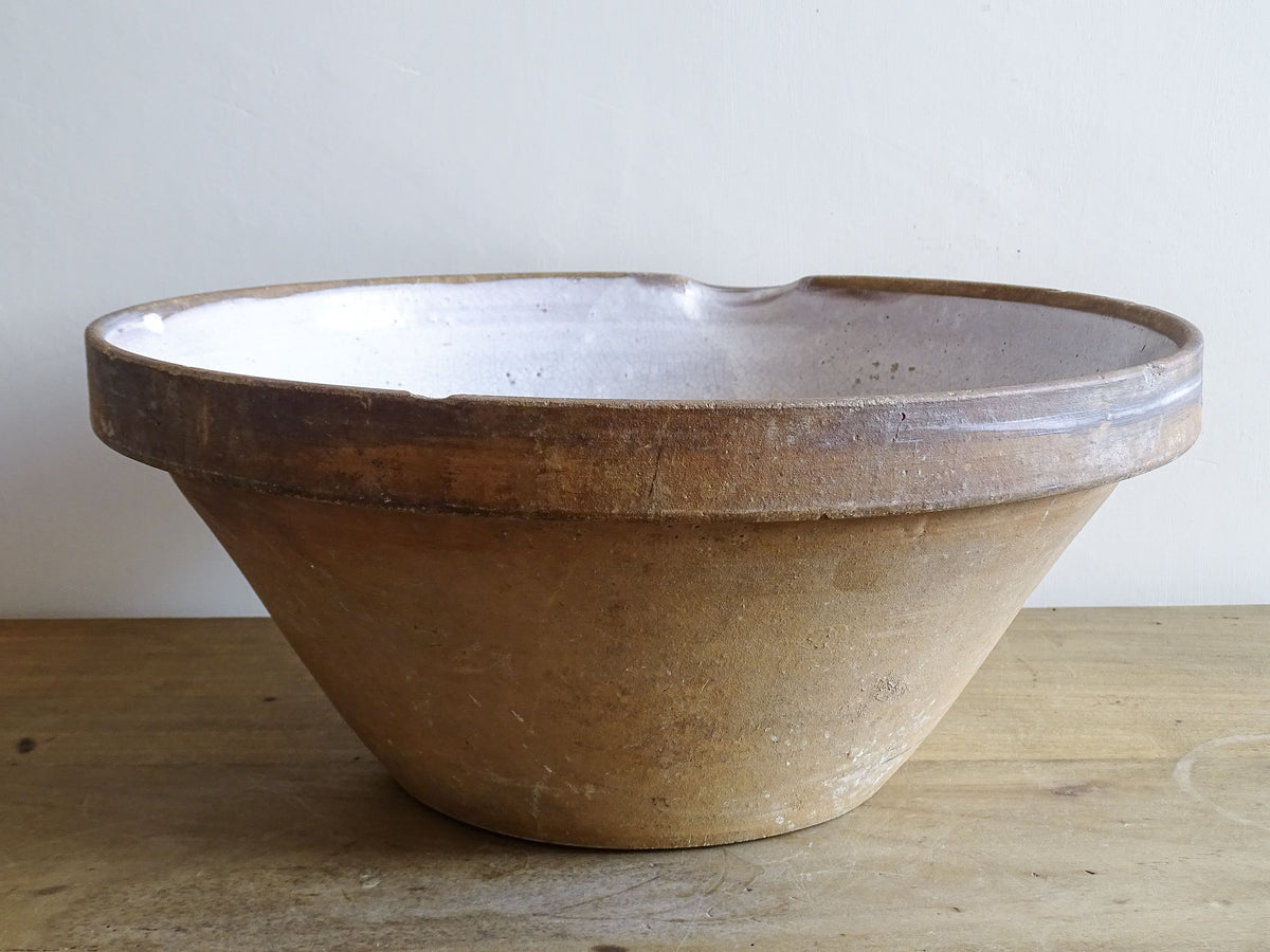 French vintage ceramic mixing bowl from Pérignac, Charente, stamped by a regional pottery workshop. This vintage terracotta bowl has a pale glazed interior and pouring lip.