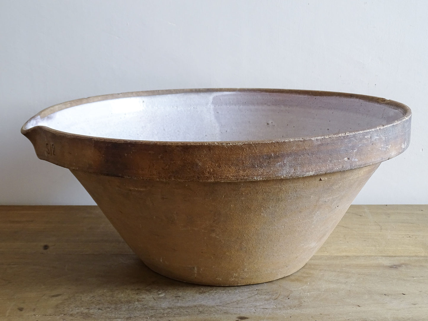French vintage ceramic mixing bowl from Pérignac, Charente, stamped by a regional pottery workshop. This vintage terracotta bowl has a pale glazed interior and pouring lip.