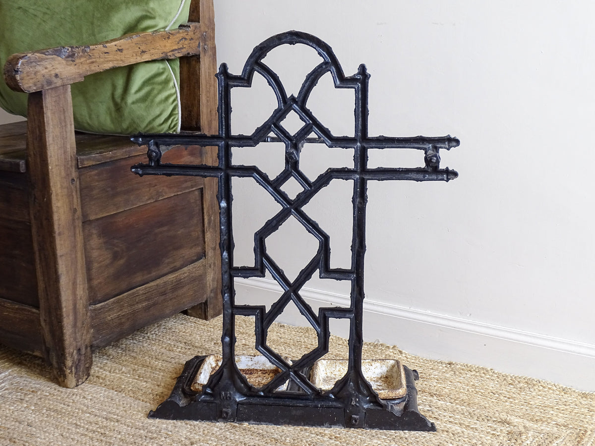 A striking French antique umbrella stand in cast iron, featuring an intricate bamboo-form design with geometric lattice detailing and original drip trays. Dating to the late 19th century