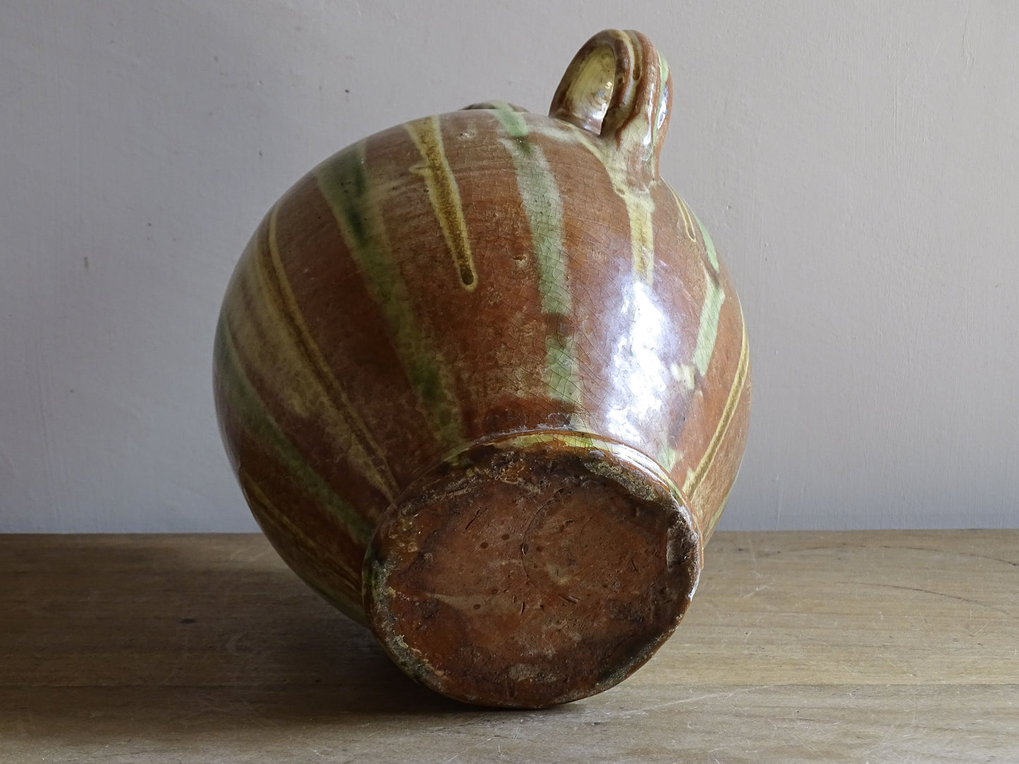 A French antique ceramic water jug or gargoulette from the South of France, dating to the late 19th century. This French antique gargoulette is formed in terracotta and finished with a flowing green and yellow glaze