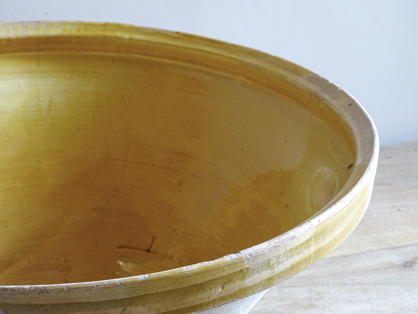 A large French antique tian bowl in pale terracotta, finished with a warm yellow glazed interior. Hand-thrown with a wide, gently flared form and a thick rolled rim. This tian bowl is typical of traditional farmhouse pottery from the South West of France.