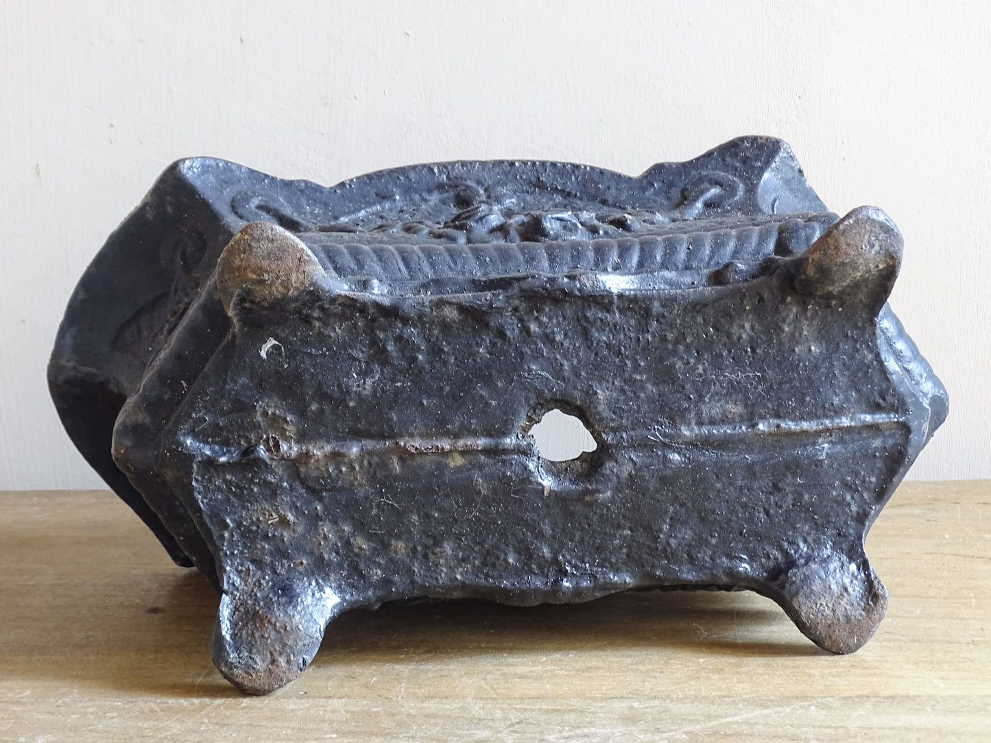 Antique French cast iron planter with worn surface and floral detail