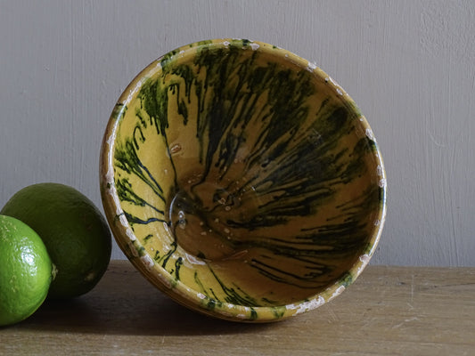 A small French antique terracotta bowl with a striking yellow ochre glaze and a traditional green jaspé decorated interior. Hand-thrown in earthenware.