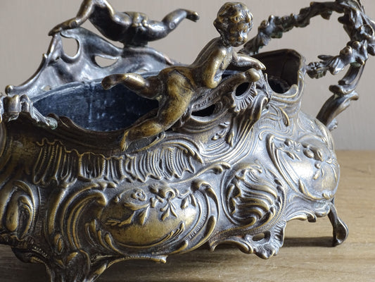 Early 20th century French metal jardinière with bronze patina and cherubs