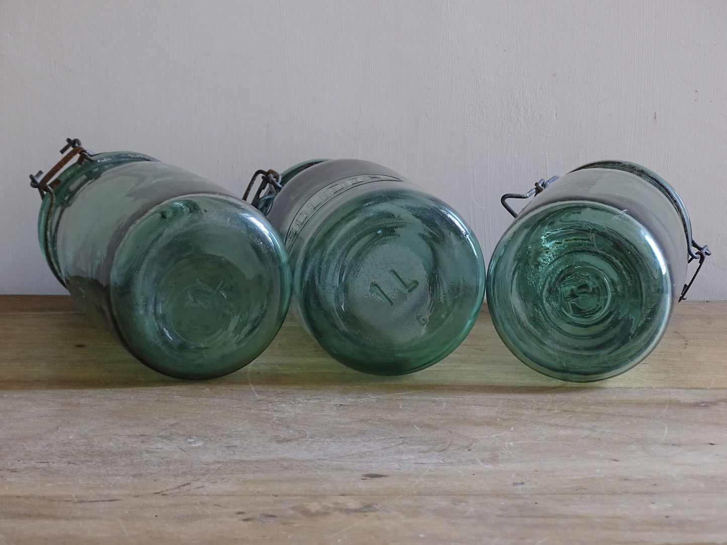 Vintage French aqua glass storage jars styled on rustic wooden table