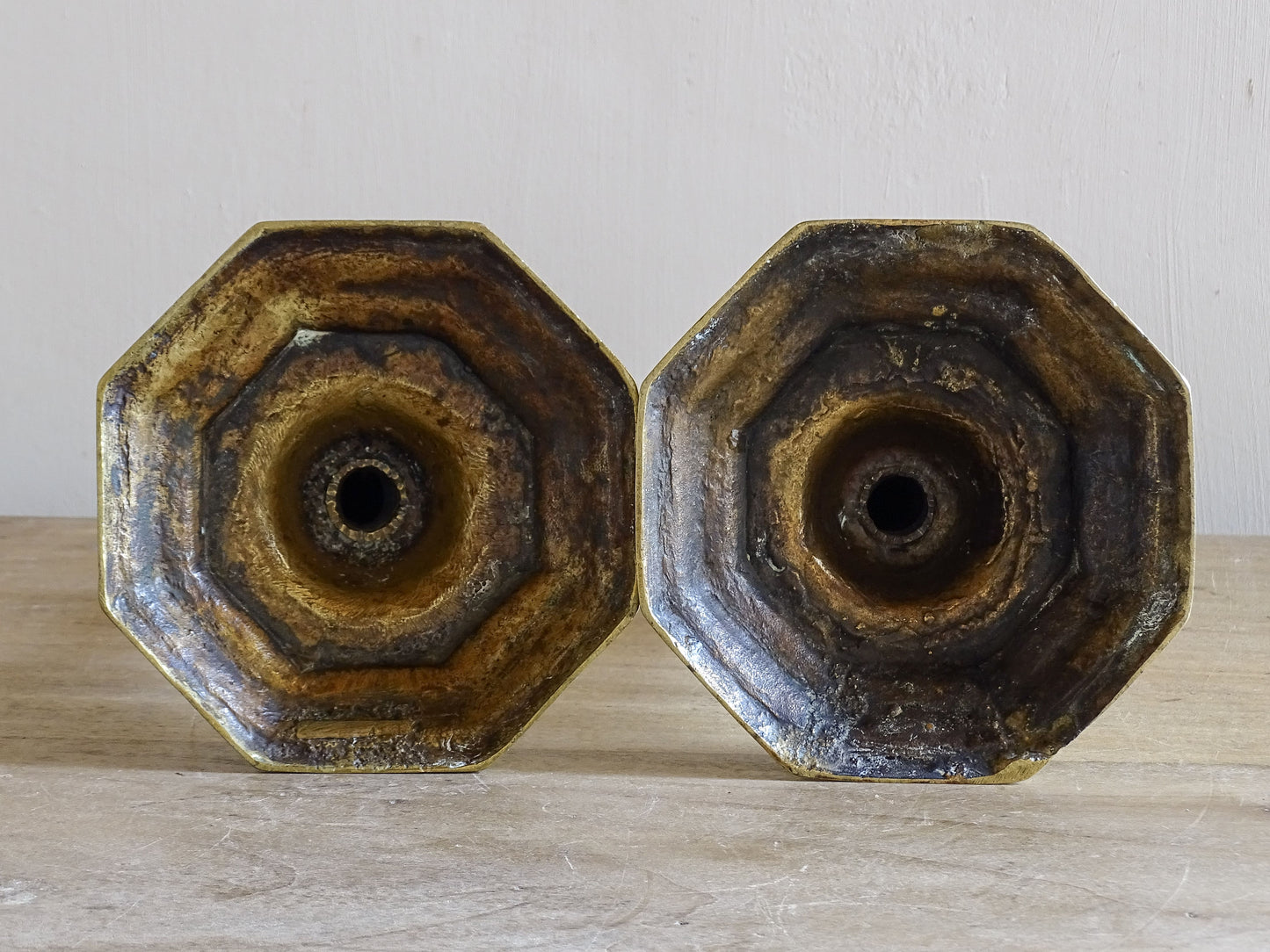 Underside of antique brass candlesticks showing aged surface and construction details
