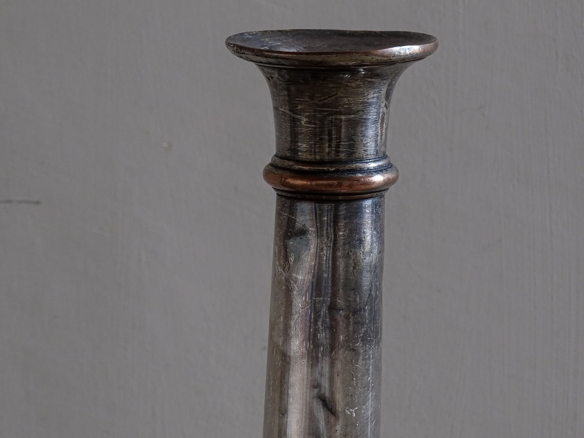 Pair of late 19th century French candlesticks in silver plate over copper with worn patina