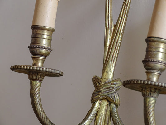 French Louis XVI style twin arm wall lights with aged gilt finish