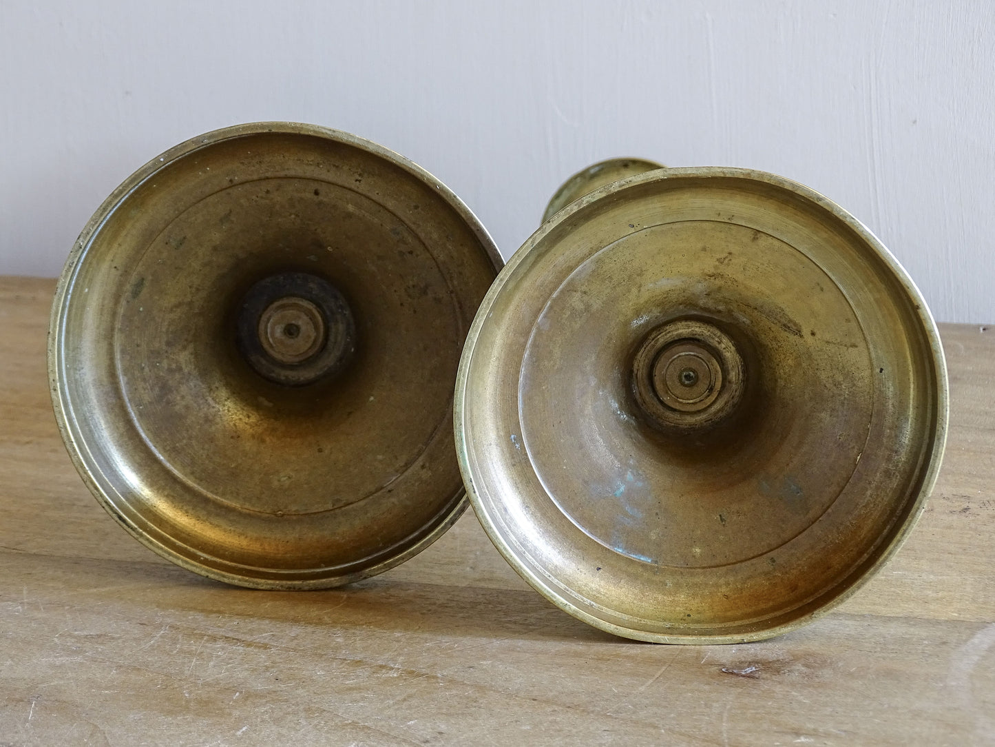 Underside of antique brass candlesticks showing traditional construction.