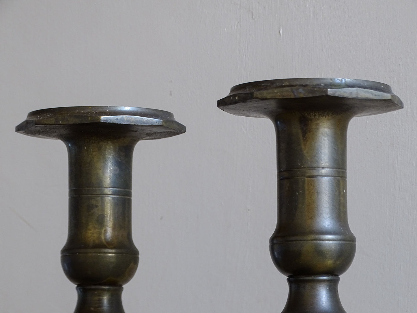 Close-up of the broad candle holders and baluster-shaped tops of antique French candlesticks