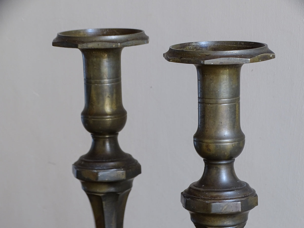 Close-up of the broad candle holders and baluster-shaped tops of antique French candlesticks