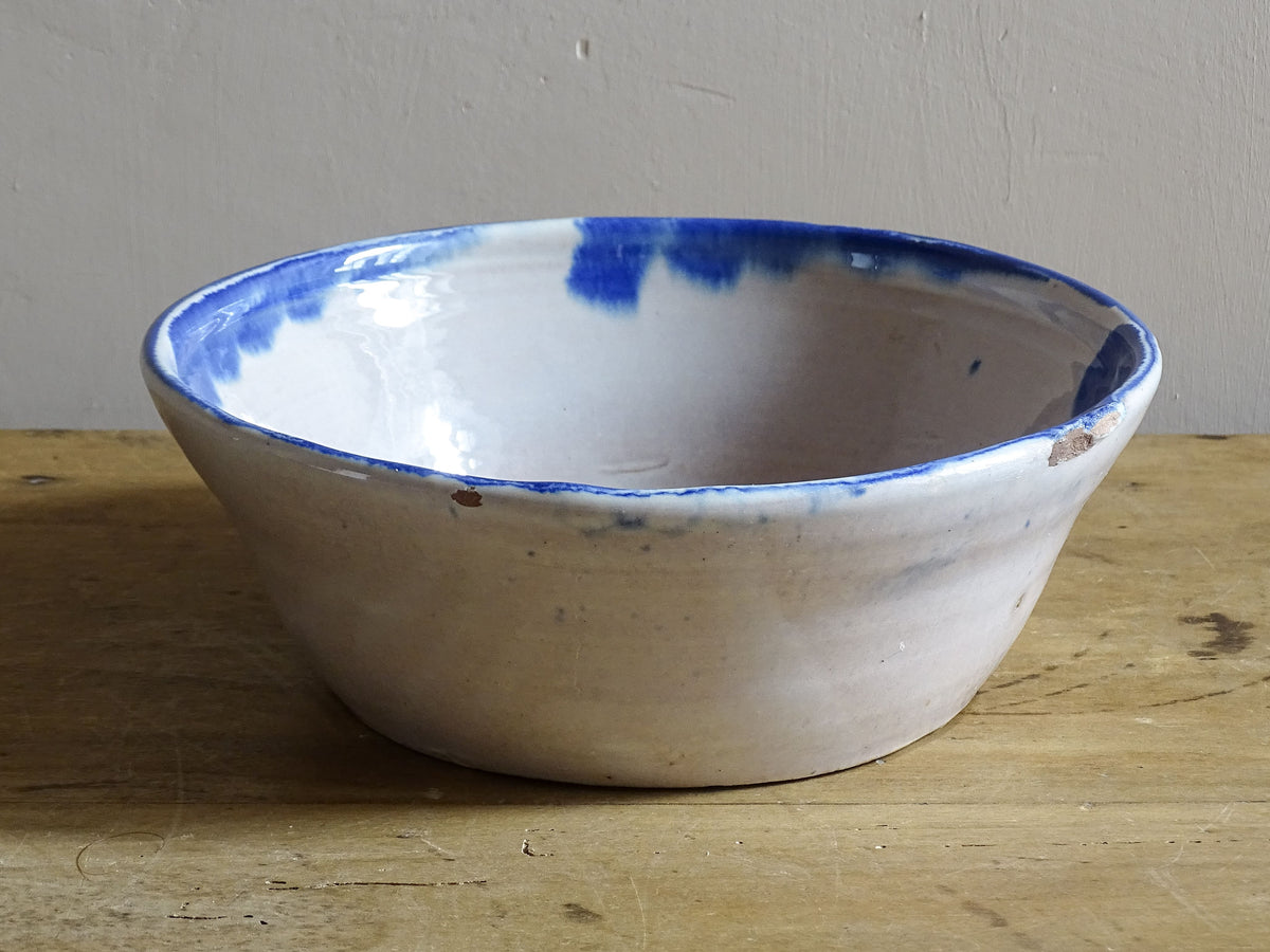 Side view of a vintage Spanish Fajalauza bowl with an irregular hand-thrown shape and cobalt blue