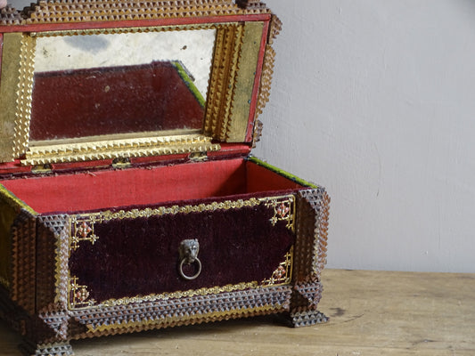 Antique tramp art sewing box opened to show its red fabric-lined compartment and single mirror fitted inside the hinged lid.