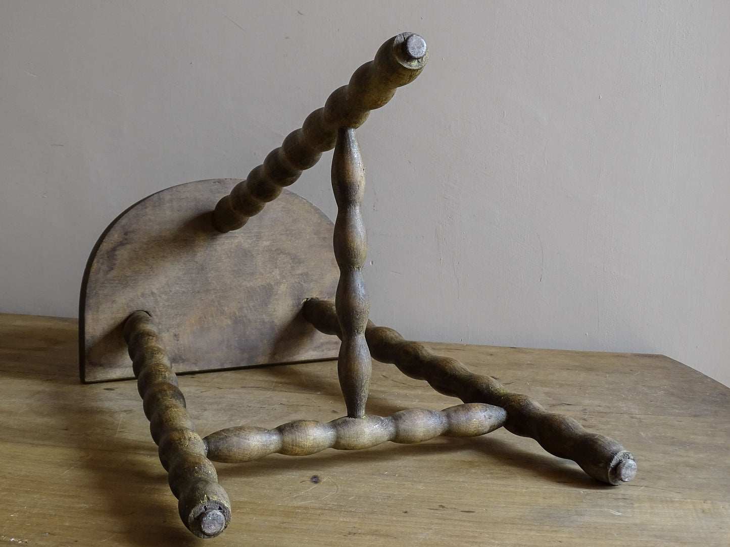 Characterful vintage wooden stool with curved seat and turned legs