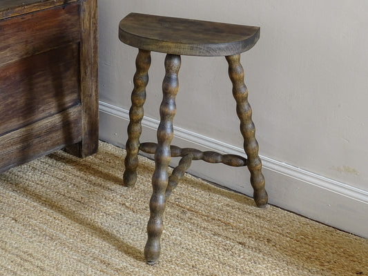 Rustic French wooden stool with a curved half-moon seat