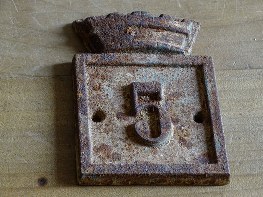 Antique-style cast iron number 5 house plaque from Beaumont-du-Périgord, showing the raised numeral and distinctive architectural top.