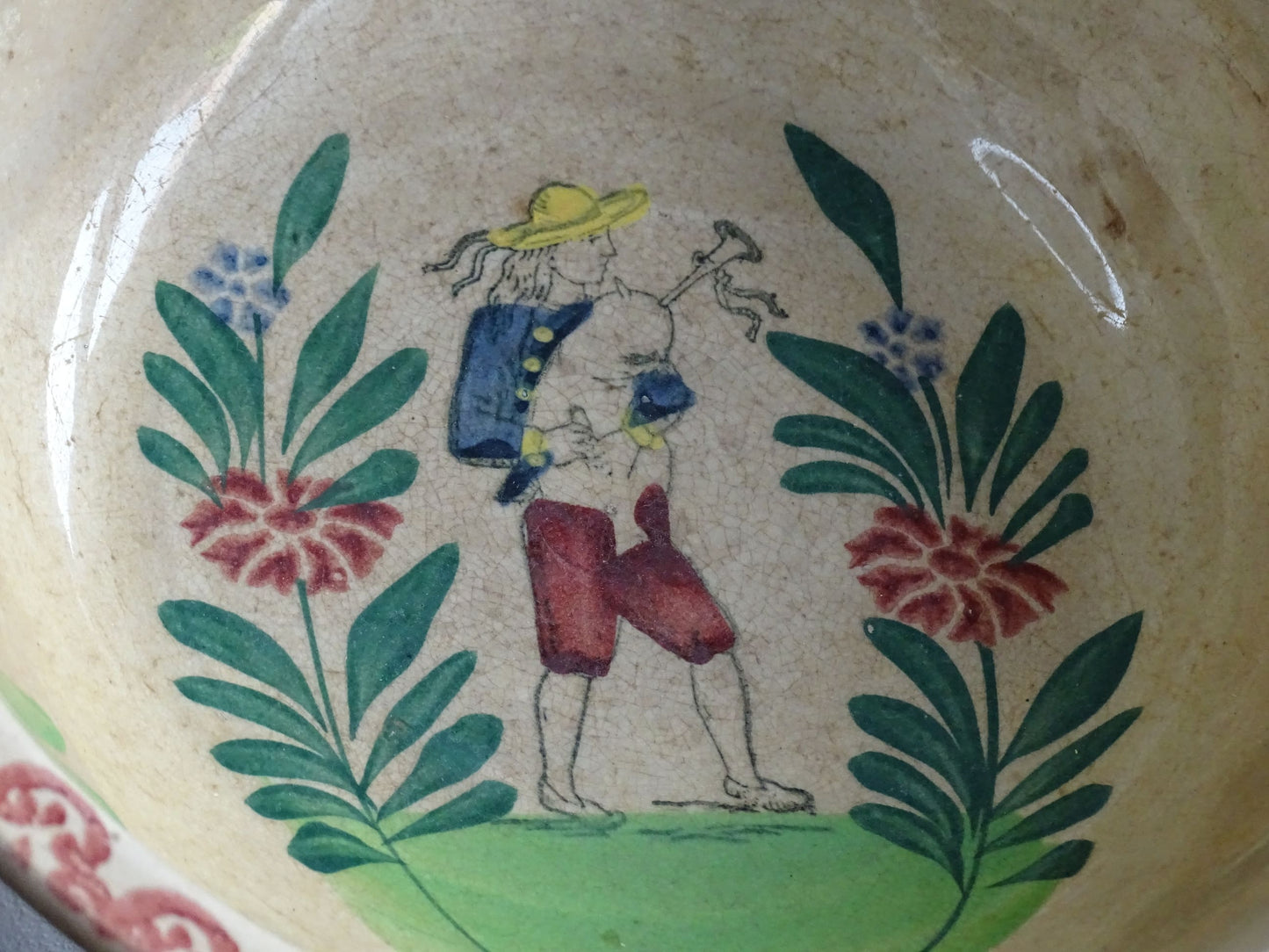 Antique Saint Amand Salad Bowl with Figure of a man and foliage and flower decoration