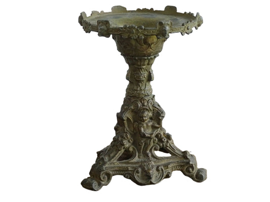 Ornate French antique cast iron candle holder with tripod base and decorated with cherubs.