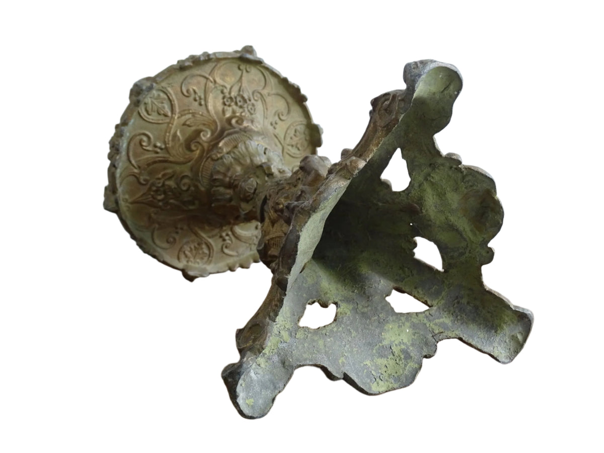 Ornate French antique cast iron candle holder with tripod base and decorated with cherubs.