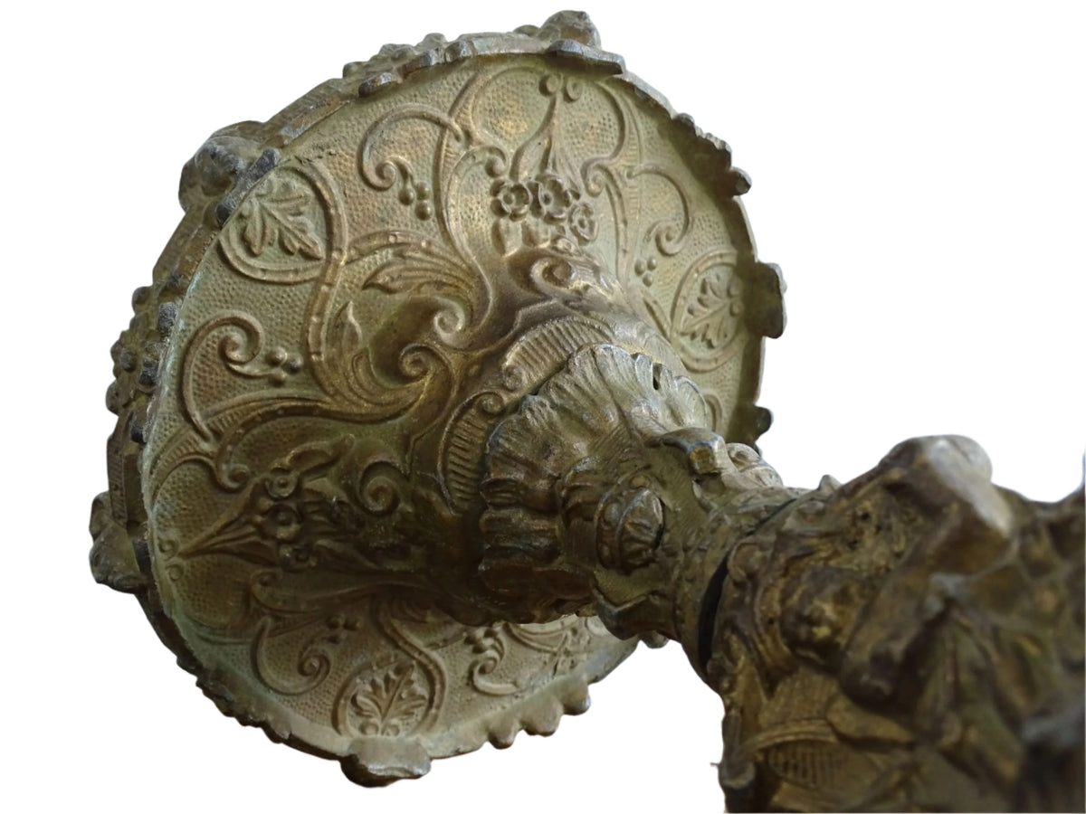 Ornate French antique cast iron candle holder with tripod base and decorated with cherubs.