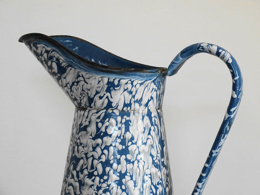 Large French vintage enamel pitcher in blue and white with a decorative swirl effect. Enamelware pitcher with large handle and spout. Vintage enamel jug for kitchen decor.