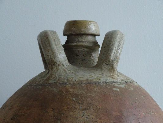 Large French antique terracotta pitcher. Rustic jug with a red brown tone to the body and a lighter tone to the two loop handles and spout. It has a rounded body and neutral tones. Antique earthenware pottery for rustic farmhouse decor.