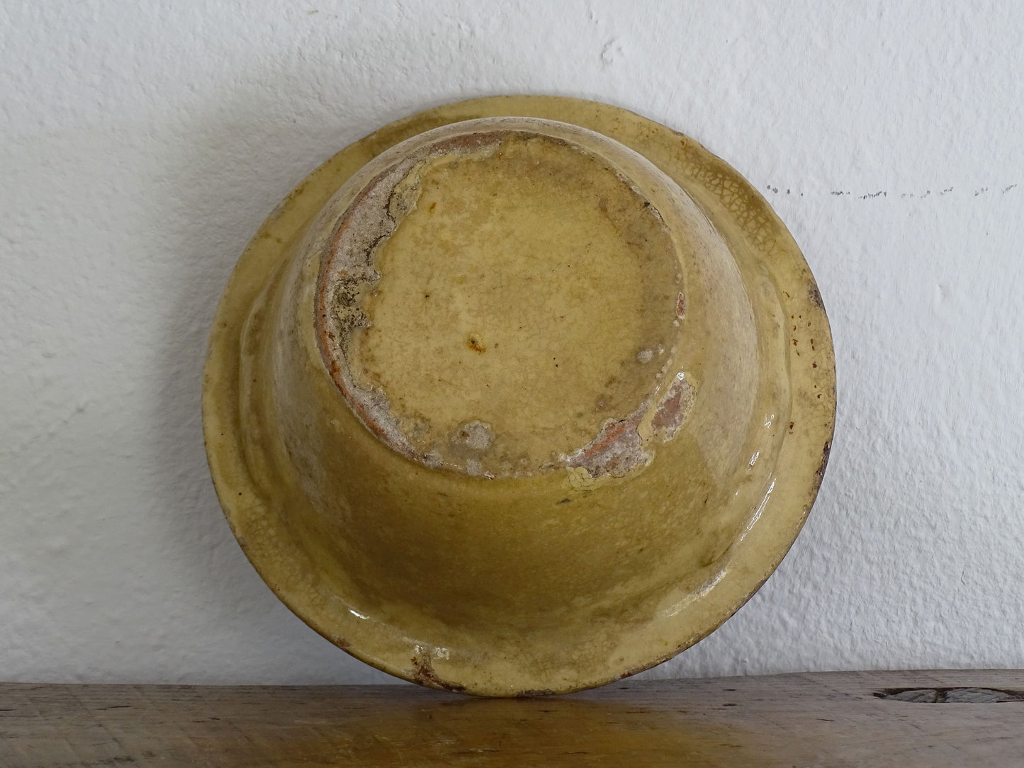 a rustic Small French antique terracotta pottery mixing bowl with a pale yellow glaze
