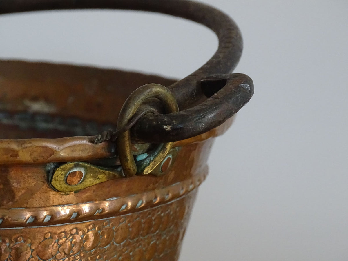 Small vintage copper cauldron with a hammered effect. It has a wrought iron handle and delicate brass detailing. Small copper cauldron or planter.