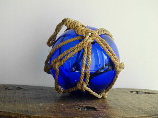 Vintage glass buoy in blue glass and natural rope