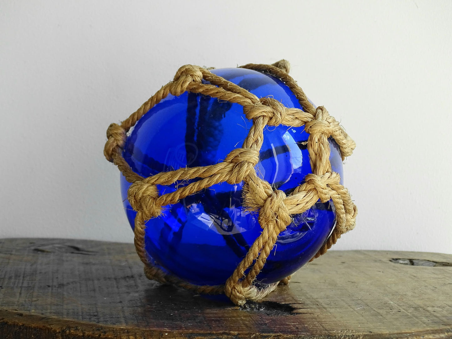 Vintage glass buoy in blue glass and natural rope