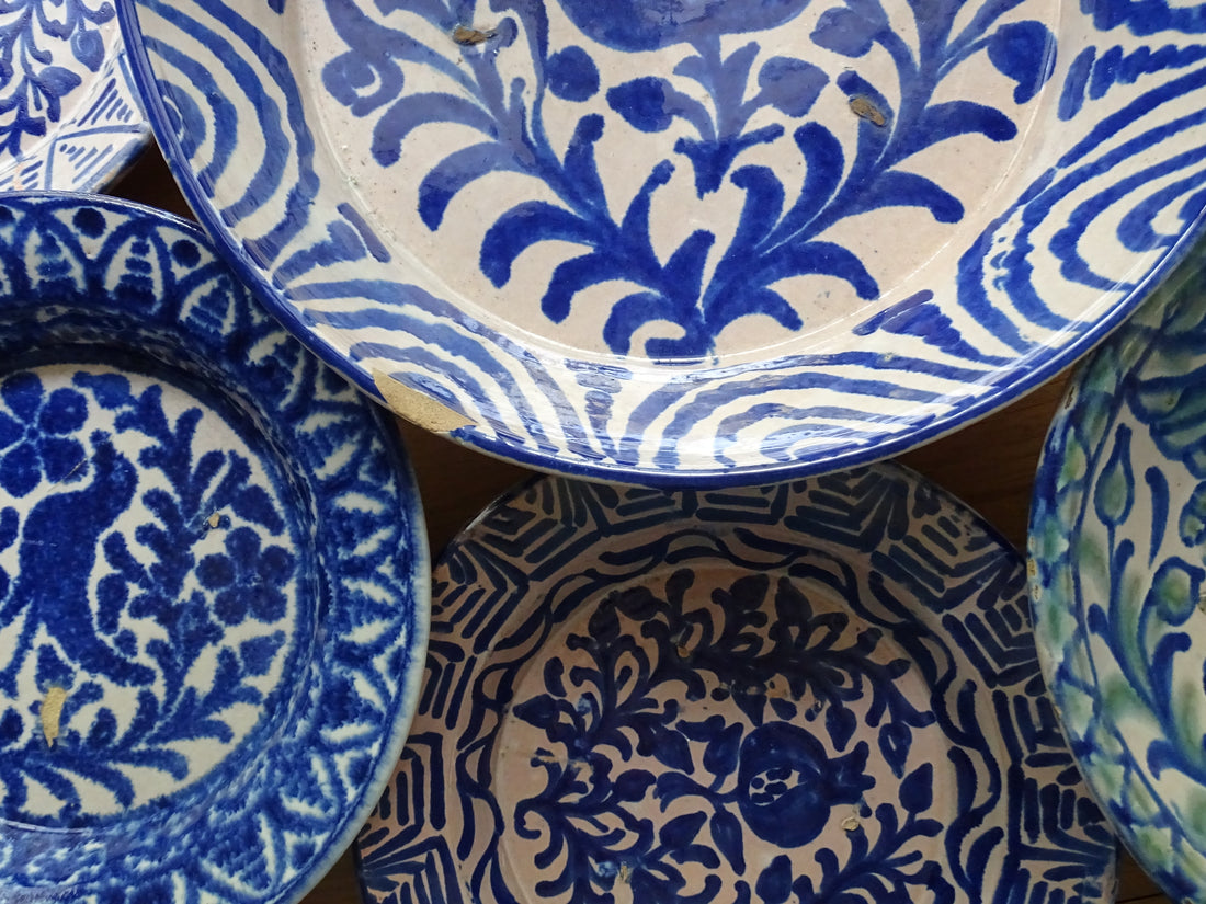 A collection of antique fajalauza pottery bowls or lebrillos, hand-painted in blues and greens with birds and pomegranates. 