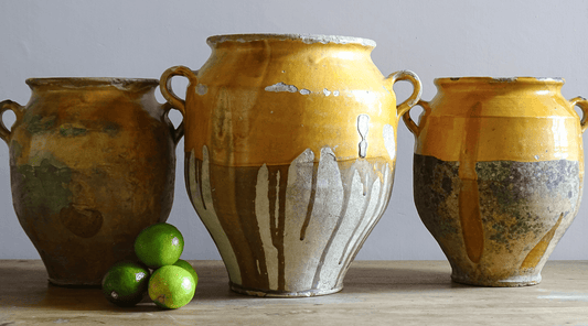 Collection of antique French confit pots with yellow glaze.