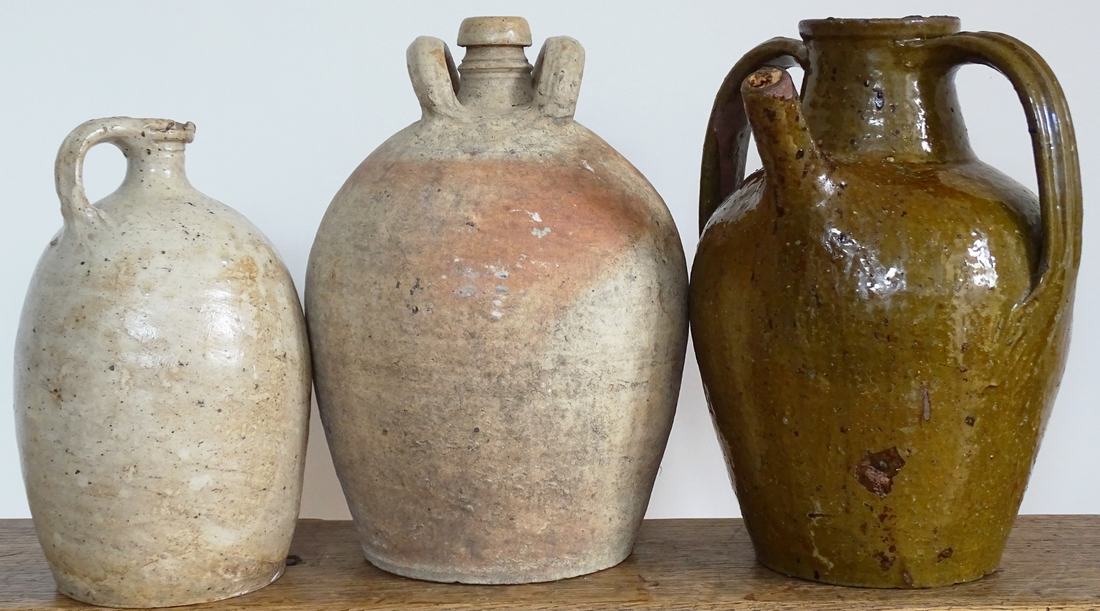 French antique terracotta pitchers, two unglazed earthenware pots and a green glazed walnut oil jug. 