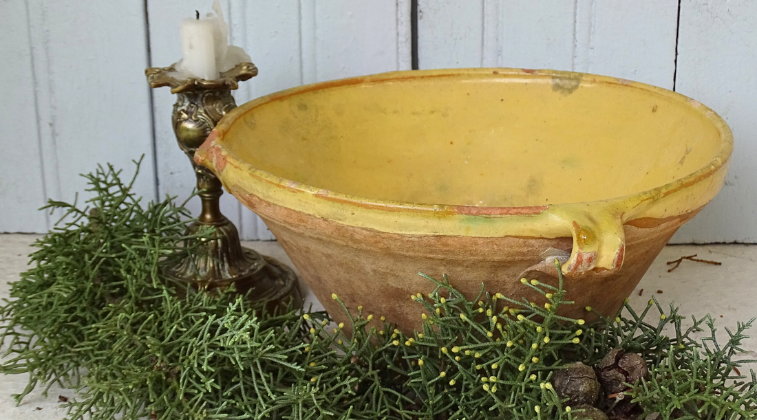 French country Christmas decor with a French antique tian bowl with a yellow glaze and festive foliage