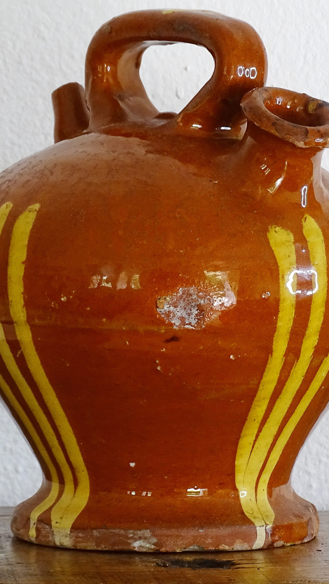 Antique French terracotta jug with red glaze and yellow stripes