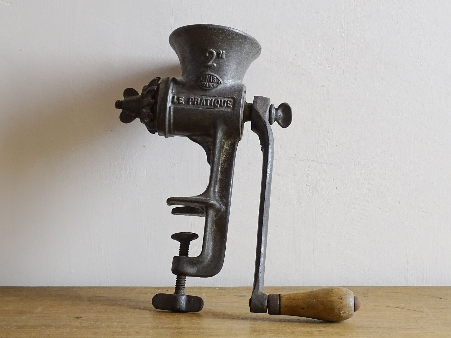 French vintage meat grinder marked 'Le Practique' with wooden handle