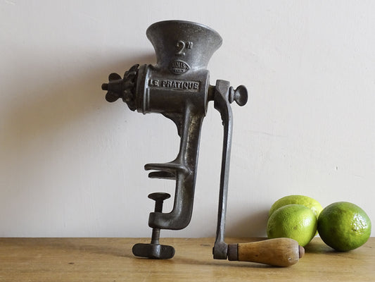 French vintage meat grinder marked 'Le Practique' with wooden handle