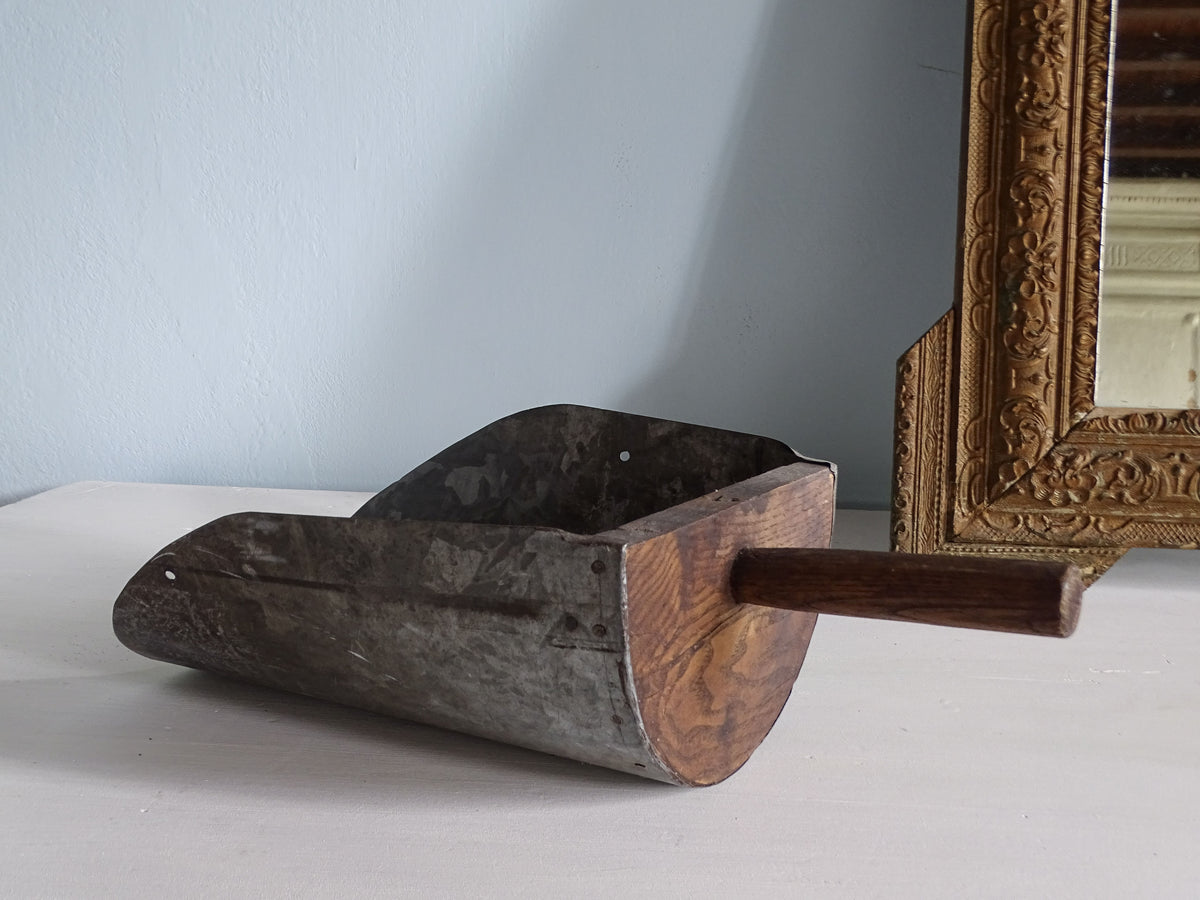 French antique wooden grain scoop with galvanised metal scoop and wooden handle, displayed next to a gold mirror