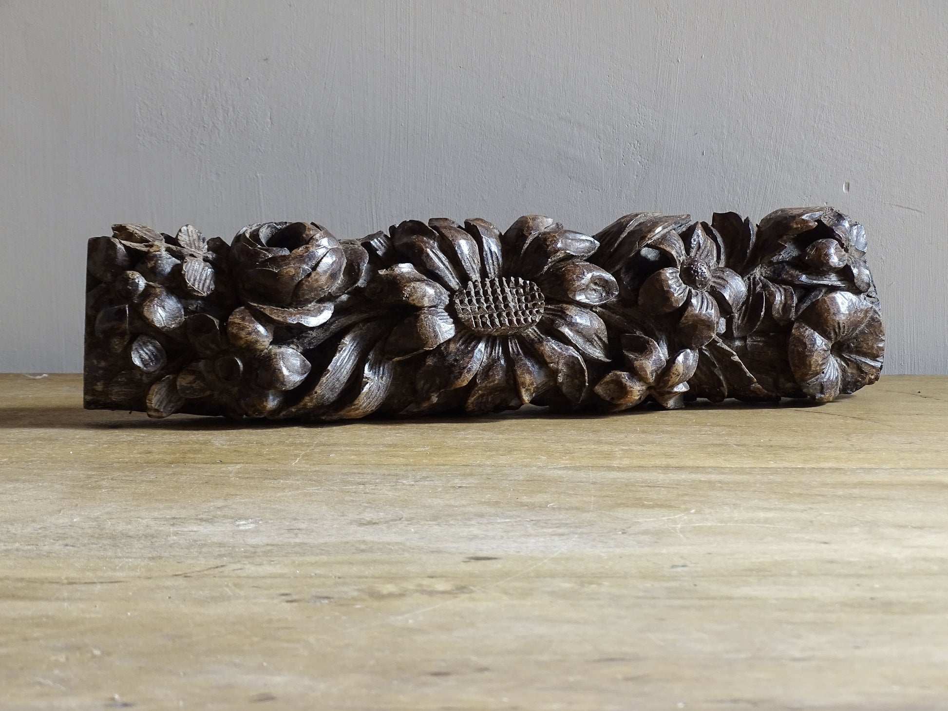 French antique wooden carving with sunflowers and roses. Old wood carving for display.