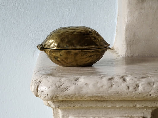 Vintage brass walnut nutcracker, displayed on a country house fireplace